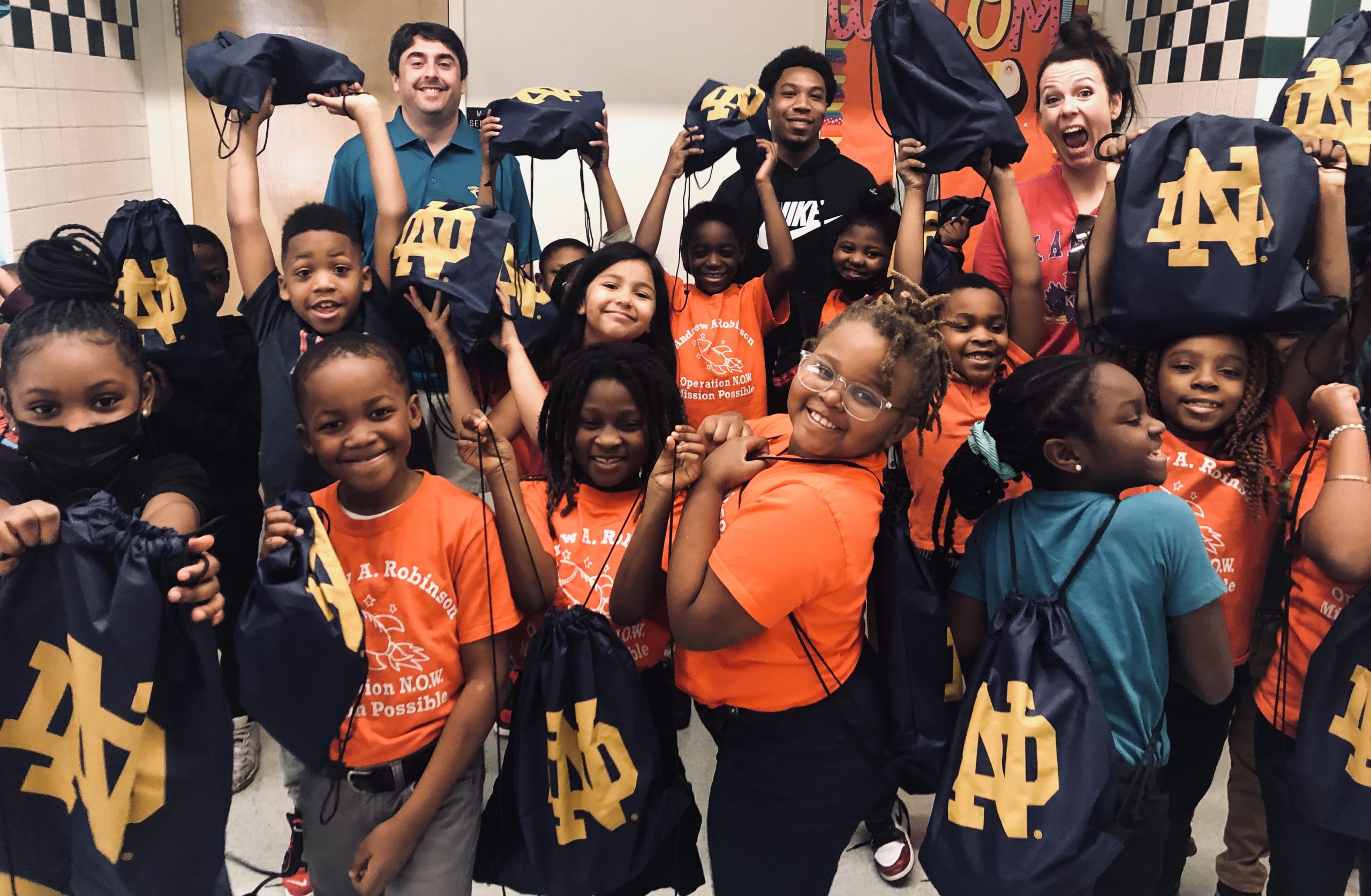 Andrew Robinson Elementary Students from Andrew Robinson Elementary pose with Notre Dame bags packed by team players.